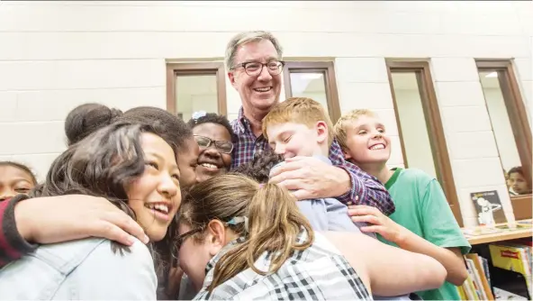  ?? BRUCE DEACHMAN ?? Students at St. Brother André School mob Jim Watson in a group hug. As mayor, Watson has both earned popular support and a reputation for being thin-skinned.