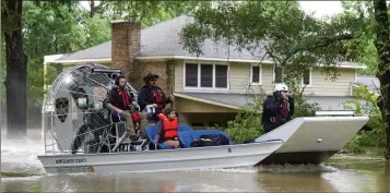  ?? JASON FOCHTMAN/HOUSTON CHRONICLE ?? A woman is rescued by airboat from her home in Conroe, Texas. Torrential rain is inundating southeaste­rn Texas, forcing schools to cancel classes and closing many highways around Houston.