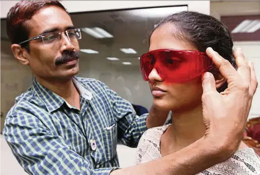  ??  ?? Dhananjay Dhanorka putting on a pair of red goggles on his daughter, Arya. The goggles act as a glare reducer. — Photos: SAMUEL ONG/The Star
