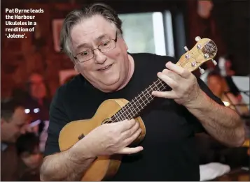  ??  ?? Pat Byrne leads the Harbour Ukuleles in a rendition of ‘Jolene’.