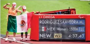  ??  ?? ÉXITO. Mónica Rodríguez subió a lo más alto del podio e impuso una marca mundial en los mil 500 metros, con un tiempo de 4:37.40. El guía de la atleta, Kevin Aguilar, posa con ella.