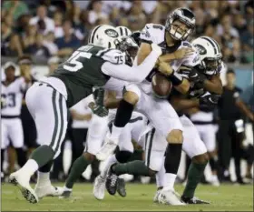  ?? MATT ROURKE - AP ?? The Philadelph­ia Eagles’ Christian Hackenberg (8) fumbles the ball while being tackled by New York Jets’ J.J. Wilcox (37) and Xavier Cooper (75) during the second half Thursday.