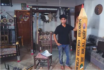  ?? AFP ?? Artist Bilal Asif poses for a photograph with his pencils art work at his studio in Karachi.
