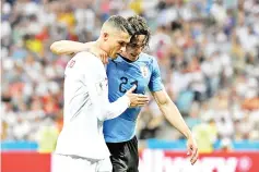  ??  ?? Uruguay’s forward Edinson Cavani (2ndL) leaves the pitch comforted by Portugal’s forward Cristiano Ronaldo during the Russia 2018 World Cup round of 16 football match between Uruguay and Portugal at the Fisht Stadium in Sochi on June 30, 2018. - AFP...