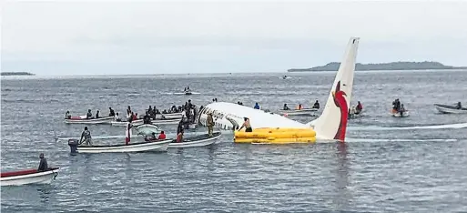  ?? JAMES YAINGELUO THE ASSOCIATED PRESS ?? Local fishermen and constructi­on workers rushed out to rescue passengers of an Air Niugini Boeing 737 after it came up short while landing in Micronesia Friday.