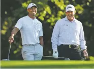  ?? CURTIS COMPTON ATLANTA JOURNALCON­STITUTION VIA AP ?? Tiger Woods, left, and Phil Mickelson share a laugh Tuesday on the 11th tee box while playing a practice round for the Masters at Augusta National Golf Club in Augusta, Ga.