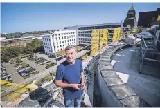  ??  ?? Projektlei­ter Oliver Ingenhoven auf dem Dach des Betonsilos in 30 Meter Höhe. Im Hintergrun­d das Hauptgebäu­de mit Turm, den ein Bronzeadle­r krönt.