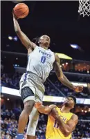  ?? WEBER, THE COMMERCIAL APPEAL MARK ?? Memphis forward Kyvon Davenport goes up for a massive dunk in front of Tennessee Tech defender Micaiah Henry during action at the FedExForum in Memphis Tenn., Tuesday, November 6, 2018.