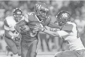  ?? Joe Buvid ?? Waltrip RB Kaleb Lastrape (5) is stopped after a short gain by Austin’s Simon Garza (20) but scored a couple of rushing touchdowns in the Rams’ victory.