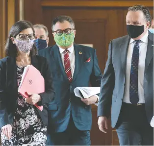  ?? JACQUES BOISSINOT THE CANADIAN PRESS ?? Premier François Legault, right, former health minister Danielle Mccann, left, and public health director Horacio Arruda, are seen in May. Quebec will resume daily COVID-19 updates.