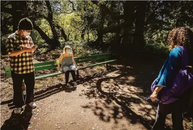  ?? Photos by Carlos Avila Gonzalez / The Chronicle ?? Ezra (left) and Shoshana Sturm walk through Golden Gate Park with their mother, Marjorie Sturm.