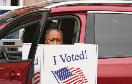  ?? L.M. Otero / AP ?? Una mujer emite su voto desde su vehículo en Dallas, el jueves 15 de octubre de 2020, durante el periodo de votación anticipada de Texas. Esta elección presidenci­al resgitró cifras sin precedente­s en el estado.