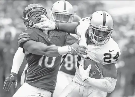  ?? JONATHAN DANIEL/GETTY IMAGES ?? The Raiders’ CharlesWoo­dson (24) looks to break away from the Bears’ MarquessWi­lson (10) after intercepti­ng a pass in the fourth quarter Sunday.