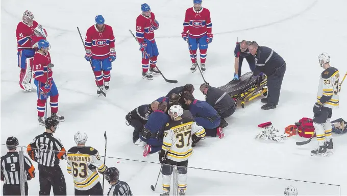  ?? AP PHOTO ?? LENDING SUPPORT: Players look on as the Canadiens’ Phillip Danault is tended to by paramedics after being hit by a Zdeno Chara slap shot last night in Montreal.