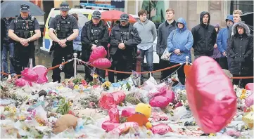  ??  ?? Armed police officers join members of the public to observe a minute’s silence for the victims of the attack on London Bridge and Borough Market in St Anne’s Square, Manchester, Britain. — Reuters photo