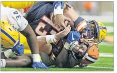  ??  ?? Syracuse’s Tommy DeVito, bottom, is sacked by Pittsburgh’s Deslin Alexandre during the Oct. 18 game in Syracuse, N.Y.