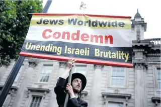  ?? AFP PHOTO ?? LOUD AND CLEAR
A member of the Ultra-Orthodox Jewish community holds an anti-Israel sign during a rally outside Downing Street, central London, United Kingdom, on May 28, 2024.