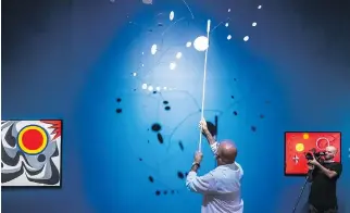  ??  ?? Richard Gagnier, head of conservati­on at the Montreal Museum of Fine Arts, rotates one of the mobiles.