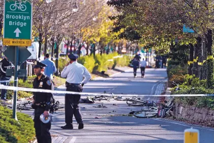  ?? CRAIG RUTTLE/THE ASSOCIATED PRESS ?? Bicycles and debris lay on a bike path after a motorist drove onto the path near the World Trade Center memorial in New York on Tuesday, striking and killing several people.