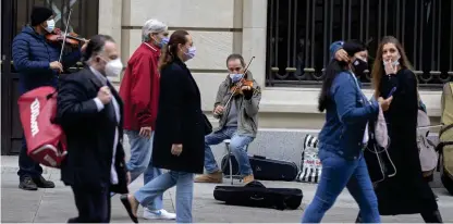  ?? Bild: Paul White ?? Gatumusika­nter spelar för förbipasse­rande i Spaniens huvudstad Madrid.