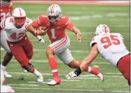  ?? Jamie Sabau / TNS ?? Ohio State quarterbac­k Justin Fields (1) picks up yardage in the second quarter as Nebraska’s Nick Henrich (42) and Ben Stille (95) defend in Columbus, Ohio, on Oct. 24.