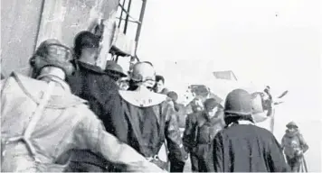  ?? U.S. NAVY ?? Men balance themselves on the deck of the USS Yorktown as they prepare to abandon ship after it was hit by two Japanese aerial torpedoes in the Battle of Midway in 1942. The Yorktown was located in 1998 3 miles below the surface.