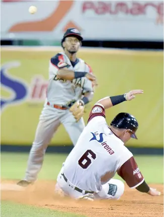  ??  ?? Alberto Triunfel, del Escogido, lanza a primera para completar una doble matanza.