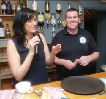  ??  ?? Michelle Johnston and Mark Reilly calling out the raffle winners at the Kilmac CFR Public Defibrilla­tor table quiz in the Grove Pub.