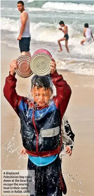  ?? ?? A displaced Palestinia­n boy cools down at the beach to escape the searing heat in their camp tents in Rafah. (AFP)