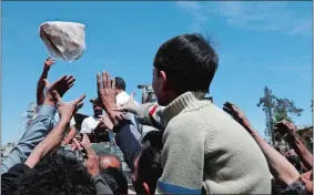  ?? HASSAN AMMAR/AP PHOTO ?? Syrian authoritie­s distribute bread, vegetables and pasta to residents in the town of Douma, the site of a suspected chemical weapons attack, near Damascus.