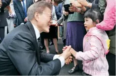  ??  ?? El presidente Moon Jae-in saluda a una pequeña, al iniciar esta mañana en Seúl sus actividade­s, que incluyeron una visita al Cementerio Nacional de Daejeon.