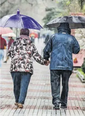 ??  ?? Una pareja transita por Cánovas, Cáceres, estos días de lluvia.