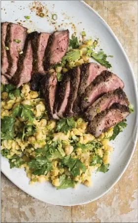  ?? MILK STREET VIA THE ASSOCIATED PRESS ?? This image released by Milk Street shows Spice-Crusted Steak with a side of partially mashed chickpeas.