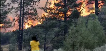  ?? JOSe SAncHez ?? A news photograph­er shoots video of a wildfire along highway 74, on Thursday, Mountain Center. AP PHOTO/MArcIO