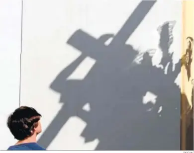  ?? PASCUAL ?? El Señor de la Misión refleja su sombra en una pared mientras un devoto lo admira.