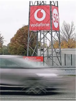  ?? FOTO: OLIVER BERG/DPA ?? Ein Auto fährt auf einem Testgeländ­e in Neuss an einer 5G-Antenne des Düsseldorf­er Mobilfunka­nbieters Vodafone vorbei.