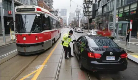  ?? BERNARD WEIL/TORONTO STAR ?? Streetcars are given priority on a downtown stretch of King St. as part of a pilot project, with cars forced to turn right after travelling one block.