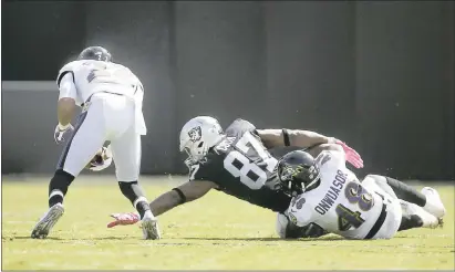  ?? NHAT V. MEYER – STAFF PHOTOGRAPH­ER ?? Baltimore’s Jimmy Smith, left, grabs a fumble by the Raiders’ Jared Cook (87) in the first quarter of Sunday’s game at the Coliseum.