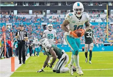  ?? JIM RASSOL/STAFF PHOTOGRAPH­ER ?? Dolphins WR Kenny Stills catches a 4th-quarter touchdown pass over Buster Skrine. Stills had two TD catches in the period.