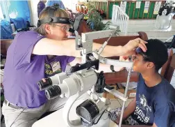  ??  ?? Dr Daniel examines a patient during a free eye care clinic at Steertown Methodist Church organised by Sandals Foundation and iCARE Care Great Shape Inc.