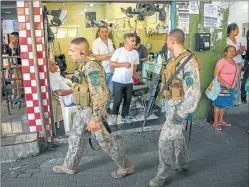  ??  ?? VIGILANCIA. El Ejército patrulla entre los locales de la Rocinha.