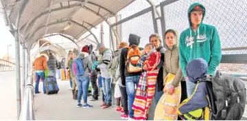  ?? — AFP photo ?? Cuban and Central American migrants queue at the Paso del Norte Internatio­nal Bridge in Ciudad Juarez, Chihuahua State, Mexico, to cross the border and request political asylum in the United States.