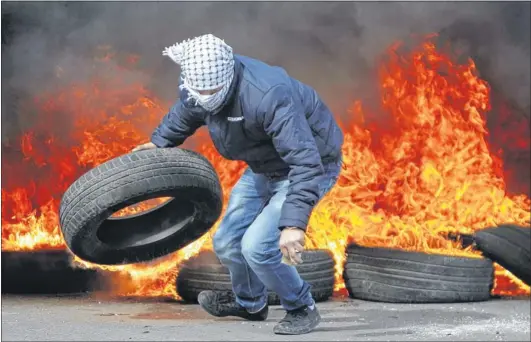  ?? Picture: AP ?? RAGING: A protester burns tyres during a show of solidarity with Palestinia­n prisoners outside Ofer, an Israeli military prison near the West Bank city of Ramallah.