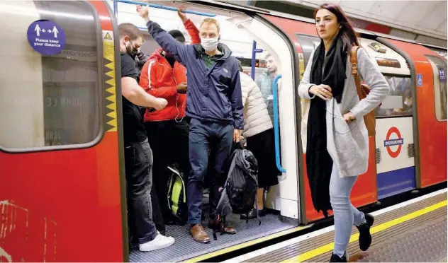  ?? Agence France-presse ?? ↑
Commuters, some wearing face coverings to help prevent spread of the virus, ride an undergroun­d train in London on Wednesday.