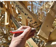  ?? ?? Jeder Besucher kann seine Wünsche, Gedanken oder Ängste auf die Holzlatten schreiben.