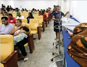  ?? ERALDO PERES/AP ?? Dengue patients wait to receive treatment in a provisiona­l clinic in the Santa Maria neighborho­od of the capital city of Brasilia late last month.