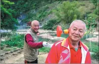  ?? JIANG XUELIN / FOR CHINA DAILY ?? Wang Tianjun (right), from Henan province, tries to take in the sights as his friend practices diabolo recently at a tourist area in Bama, Guangxi Zhuang autonomous region.