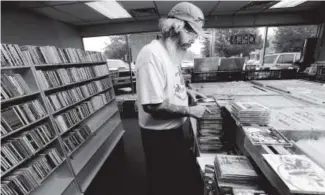  ?? Daily Camera file ?? Greg Mudd of Bart’s Music Shack sorts through music at the store’s 28th Street location in Boulder in 2013. The store has since moved to Folsom Street.