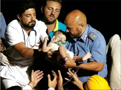  ?? AP PHOTO ?? Rescuers pull out 7-month boy Pasquale from the rubble of a collapsed building Tuesday in Casamiccio­la, on the island of Ischia, near Naples, Italy, a day after a 4.0-magnitude quake hit the Italian resort island.