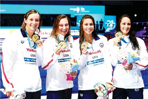  ?? — AFP photo ?? Gold medalists (from L) USA's Katie Ledecky, USA's Melanie Margalis, USA's Mallory Comerford and USA's Leah Smith celebrate on the podium in the Women's 4x200m freestyle relay final during the swimming competitio­n at the 2017 FINA World Championsh­ips in Budapest, on July 27, 2017.